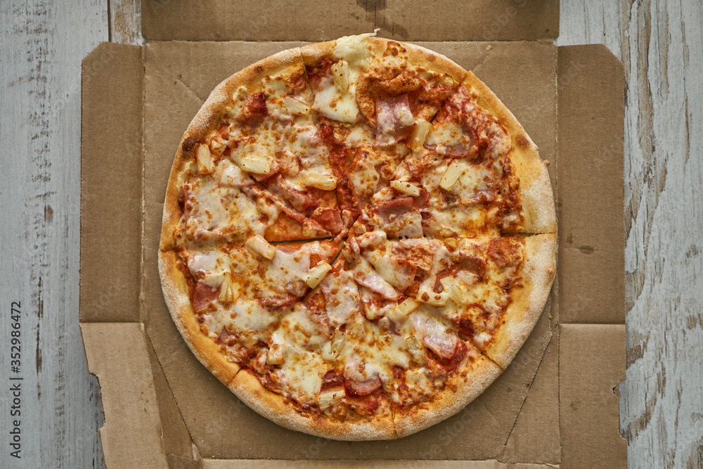 Pizza assorted pepperoni in a box and on a white plate. Fresh hot pizza with cheese and seafood. Pizza assorted pepperoni in a box and on a white plate. Fresh hot pizza with cheese and seafood.