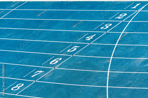 Pista de atletismo com oito raias, azul com faixas e números brancos. Faixa de largura e chegada. photo