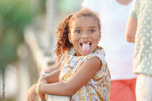 Very funny cute little girl showing tongue, with pigtails, summer, outdoors, concept childhood © lialia699