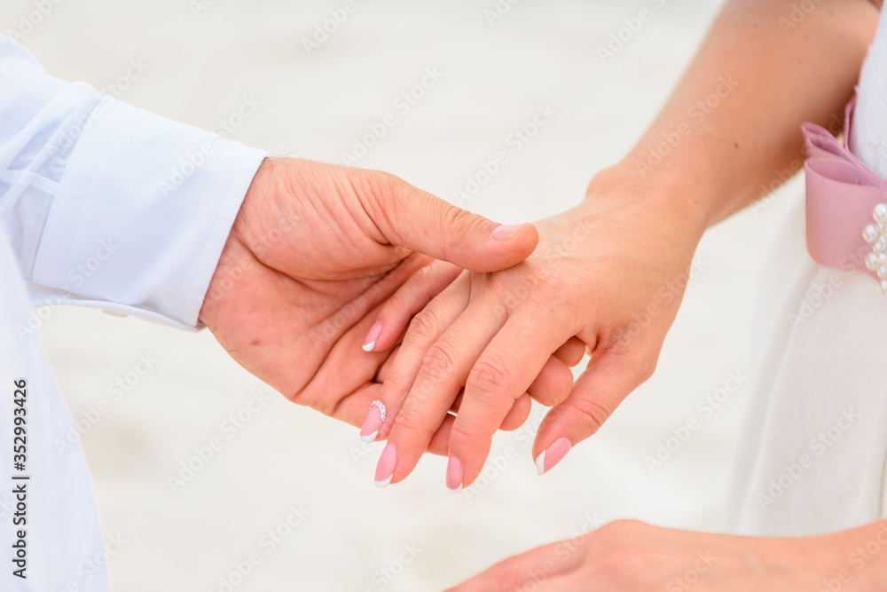 Man and woman newlyweds hold hands close-up. Man and woman newlyweds hold hands close-up.
