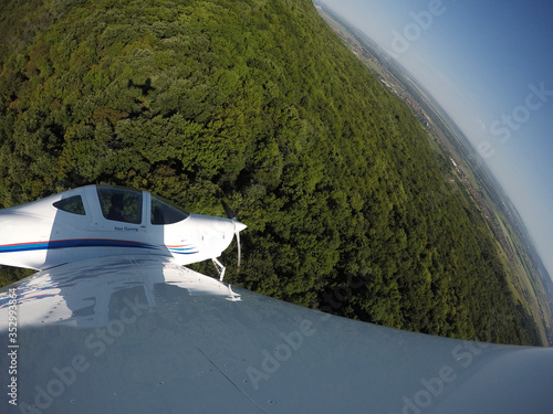 Training pilot making a steep turn over a hill. Photograph is taken from the wing of an aircraft. © M.Ecevit