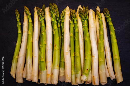 White and green fresh asparagus on the table, close up. Different varieties of German row green and white asparagus on the table.