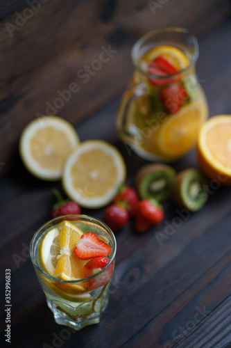 Summer refreshing citrus, strawberry and kiwi lemonade. Homemade infused water with fruits and berries. Tasty cold vitamin beverage