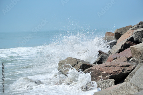 Waves breaking on large rocks on the shore