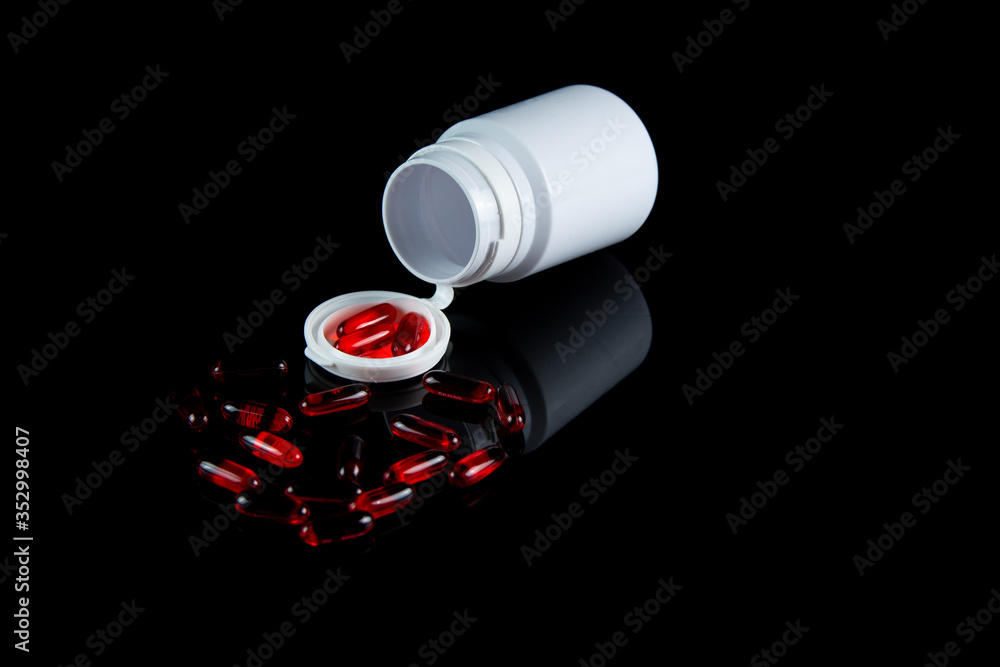 Pills spilling out of pill bottle medicine in a dark background. COVID-19 medicine concept. Pills spilling out of pill bottle medicine in a dark background. COVID-19 medicine concept.