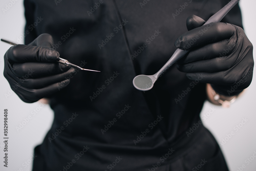 Dentistry and orthodontics. Female doctor holding dentistry tools, close up. Oral care, health and medical concept