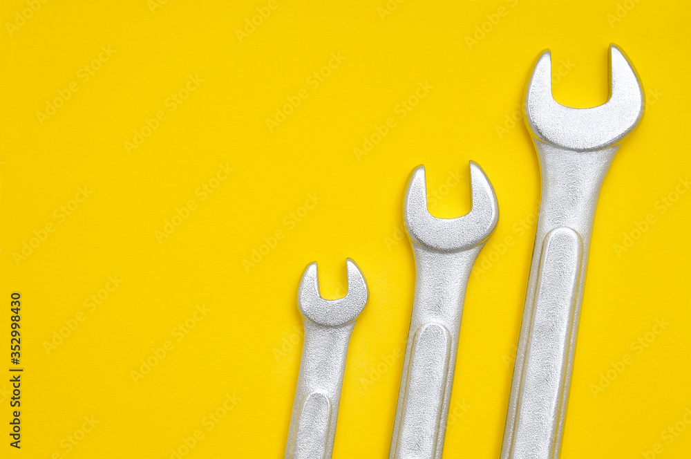 Three wrenches on a yellow background Three wrenches on a yellow background