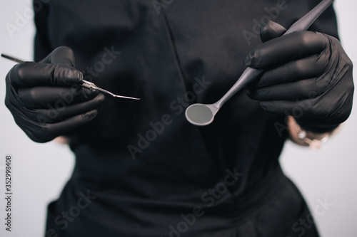 Dentistry and orthodontics. Female doctor holding dentistry tools, close up. Oral care, health and medical concept