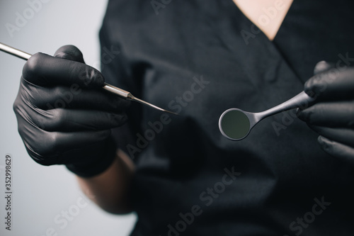 Dentistry and orthodontics. Female doctor holding dentistry tools  close up. Oral care  health and medical concept