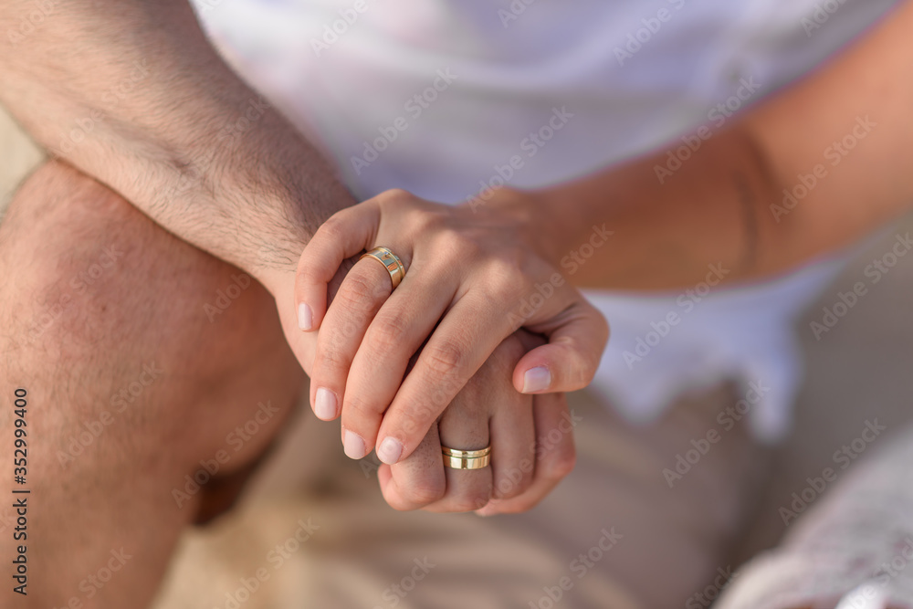 Man and woman newlyweds hold hands close-up. Man and woman newlyweds hold hands close-up.