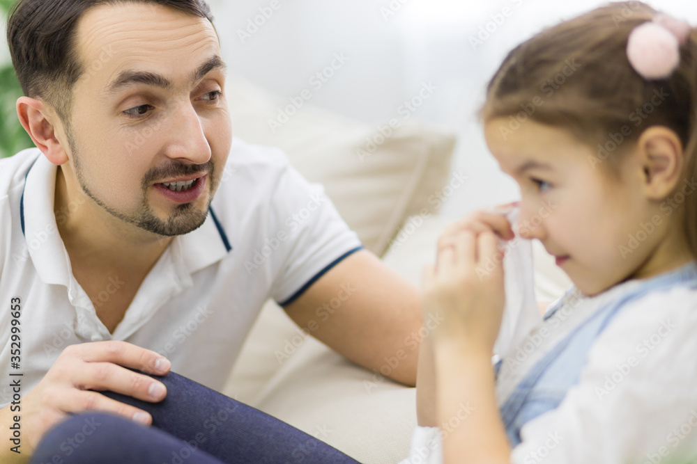 Dad is trying to calm down his daughter. Dad is trying to calm down his daughter.