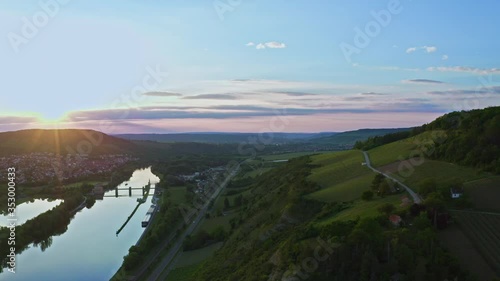 Aerial view of vineyard valley, hills, road and river. Beautiful sunset, romantic sky. Germany. Drone shot. 