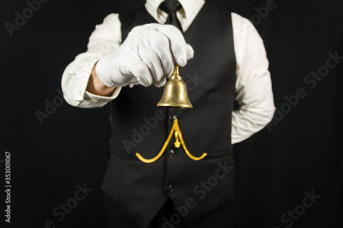 Portrait of Butler in White Gloves Holding Brass Bell. Concept of Service Industry and Professional Hospitality. Dependable Servant. Copy Space for Service.