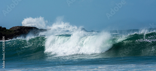 waves breaking over rocks  large swell  crystal clear water  green-blue