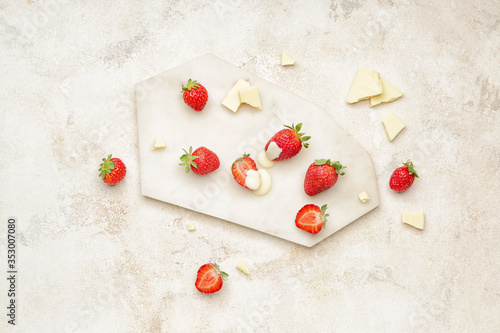 Board with tasty strawberry and melted chocolate on light background