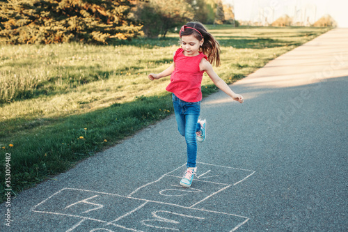 Fotografía Cute adorable little young child girl playing hopscotch outdoors