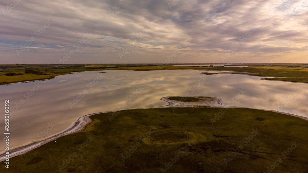An aerial view of a calm secluded lake in the prairie province of Saskatchewan, Canada at sunset
