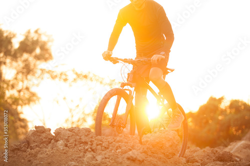 Fototapeta Naklejka Na Ścianę i Meble -  Cyclist riding mountain bike on trail at sunrise