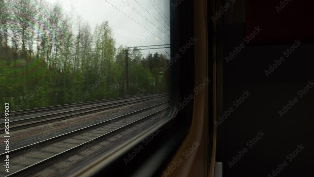 View through the window of a train from the seat of a passenger sitting back in the direction of travel. View through the window of a train from the seat of a passenger sitting back in the direction of travel.