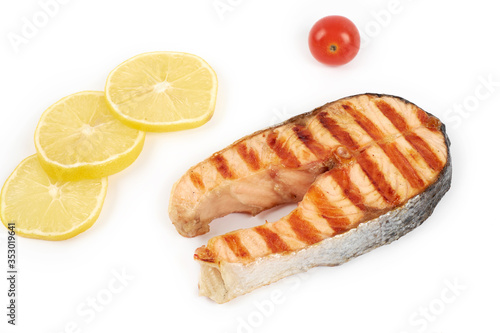 Grilled salmon steak wih lemon and tomatoes isolated on white background