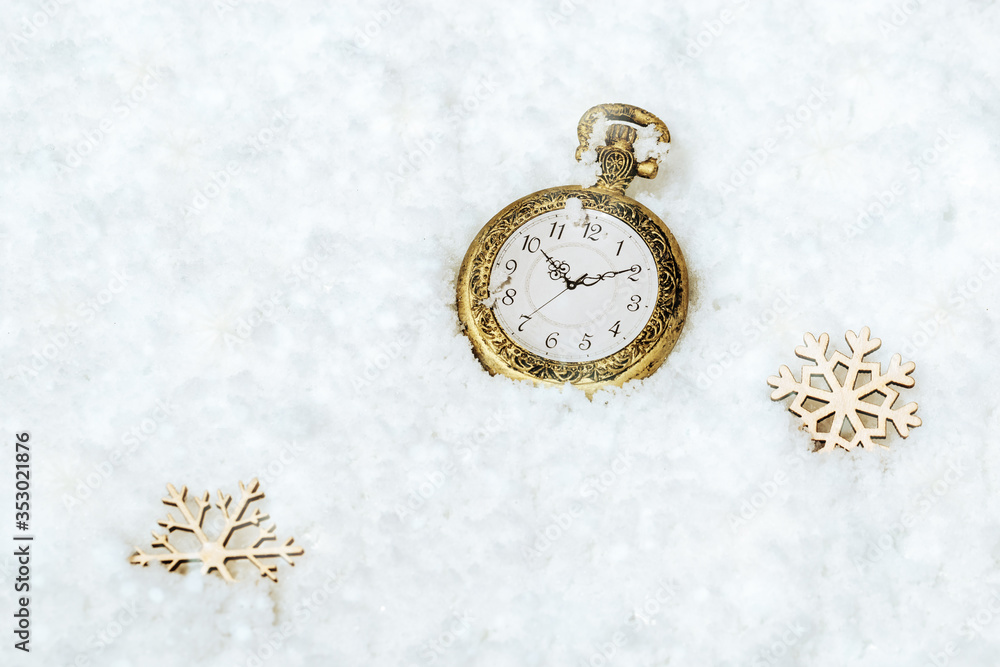 Merry Christmas and Happy New Year greeting card with vintage gold pocket clock on snow background with wooden snow flake. Merry Christmas and Happy New Year greeting card with vintage gold pocket clock on snow background with wooden snow flake.