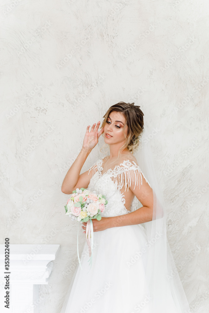 Beautiful bride with a wedding bouquet in a beautiful white room, catalog of wedding dresses, beautiful bride waiting for the groom, portrait of the bride, single bride in a beautiful dress Beautiful bride with a wedding bouquet in a beautiful white room, catalog of wedding dresses, beautiful bride waiting for the groom, portrait of the bride, single bride in a beautiful dress