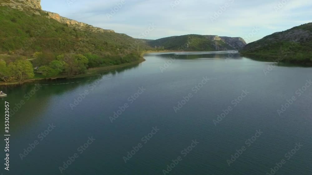 Aerial panning shot of river by mountains against sky, drone is moving from right to left - Krka, Croatia Aerial panning shot of river by mountains against sky, drone is moving from right to left - Krka, Croatia