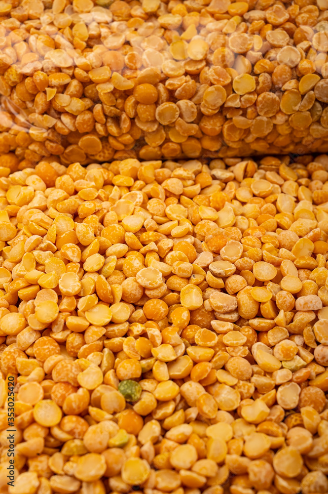 yelloYellow split peas in a plastic bag and cereal in bulk on a background of burlap with a rough texture. Traditional cereals for making soups and porridge. Close up.w crushed peas yelloYellow split peas in a plastic bag and cereal in bulk on a background of burlap with a rough texture. Traditional cereals for making soups and porridge. Close up.w crushed peas