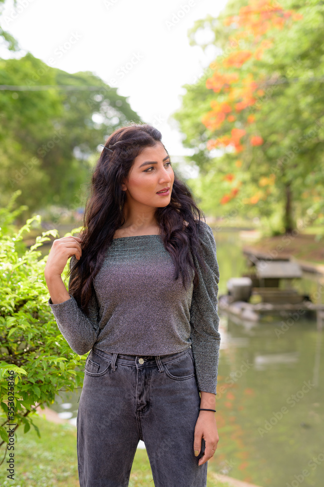 Young beautiful Indian woman thinking at the park outdoors Young beautiful Indian woman thinking at the park outdoors