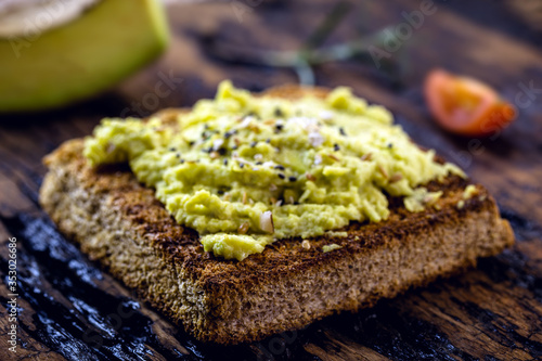 avocado pate on hot toast  with spices and spices  with vegan bread made from organic yeast. 100  vegan food.