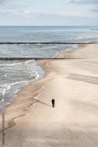 Lonely man walking on an empty beach