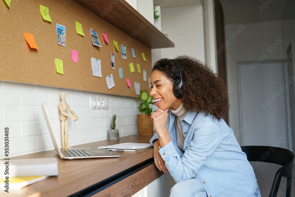 Photo Art Print Happy african american teen girl student worker wear headphones video conference calling online on laptop computer laughing at home office insta photos