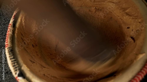 Mixing crushed raw peanuts in ceramic bowl to make peanut soup dessert photo