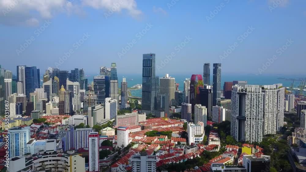 Smooth, steady, directional, aerial drone forward flight revealing futuristic Singapore city skyline apartment skyscrapers as well as green parks, trees and high rises on a sunny clear sky day. Smooth, steady, directional, aerial drone forward flight revealing futuristic Singapore city skyline apartment skyscrapers as well as green parks, trees and high rises on a sunny clear sky day.