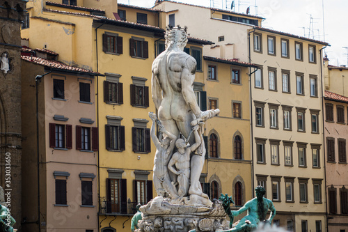 Statue of Neptune from the back with arrays of windows in the background on square Signoria. Fountain of Neptune. XVI century