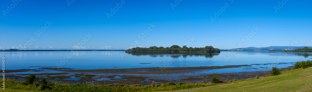 panoramic early morning view of island and reflections across Lake Illawarra, New South Wales, NSW, Australia