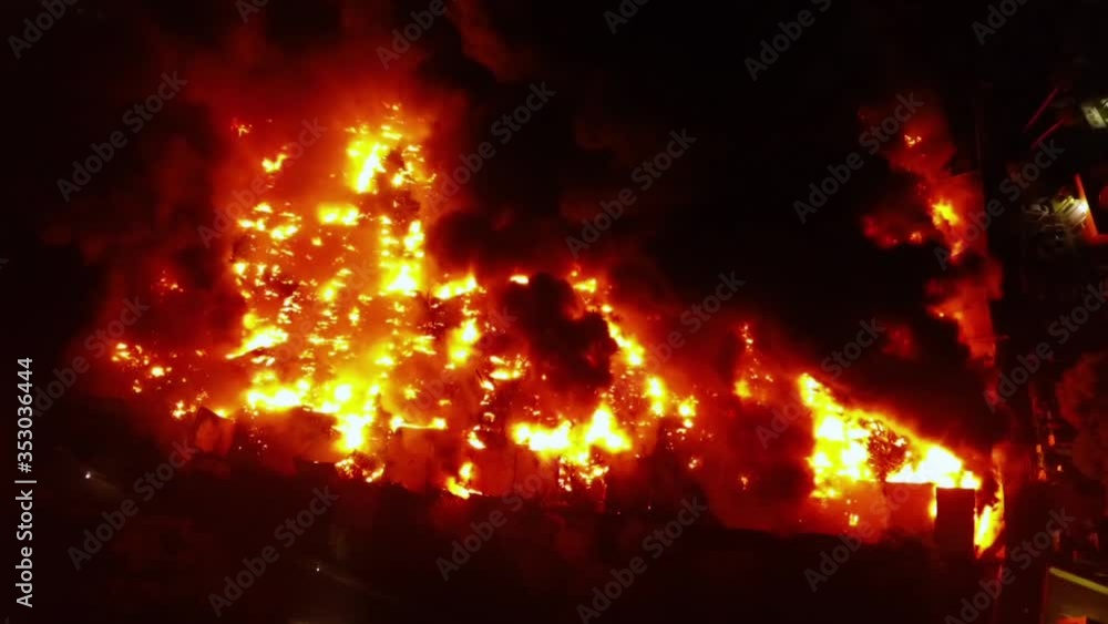 Aerial, drone shot overlooking a building on fire, during night time, in Dominican republic Aerial, drone shot overlooking a building on fire, during night time, in Dominican republic