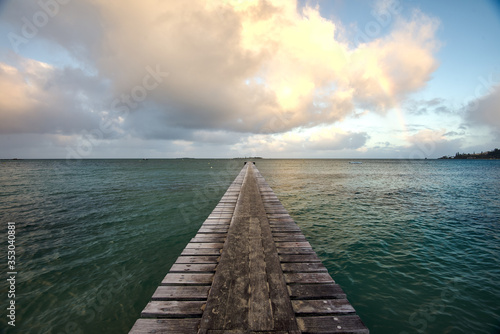 wooden jetty in the sea during sunrise