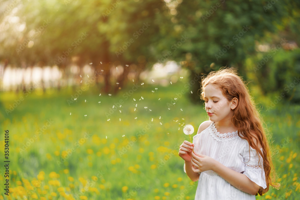 Beautiful child enjoy blowing dandelion in spring park.