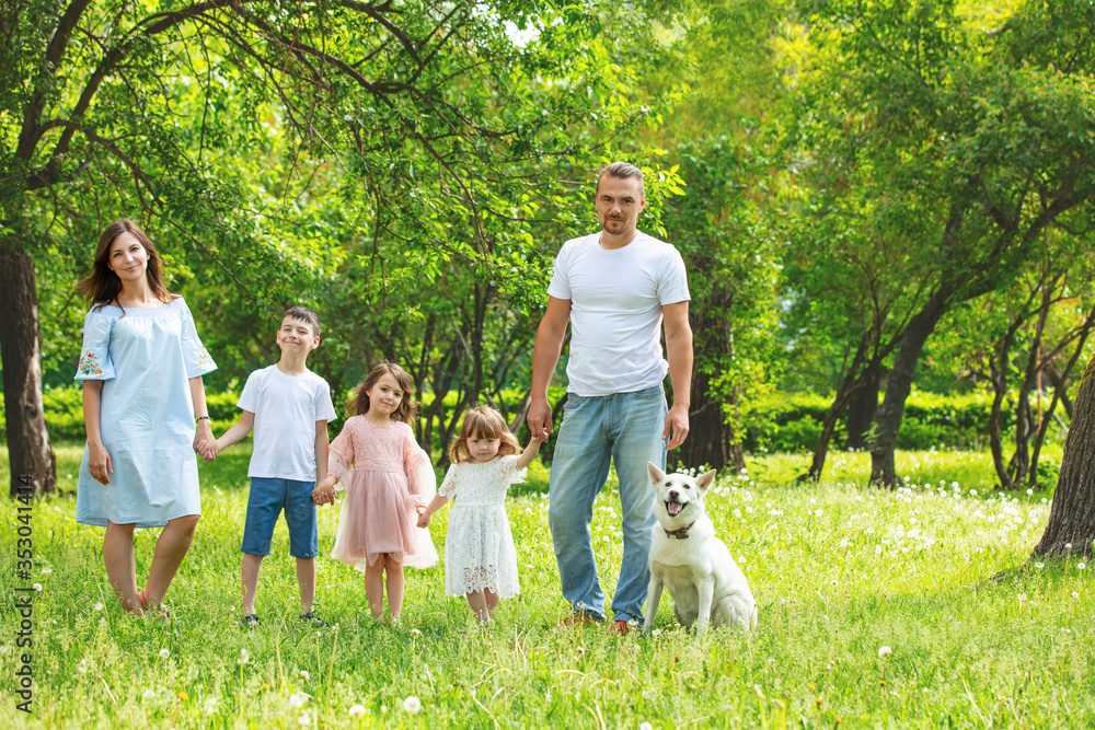 Obraz premium Happy beautiful big family together mother, father, children and dog walking on a Sunny summer day
