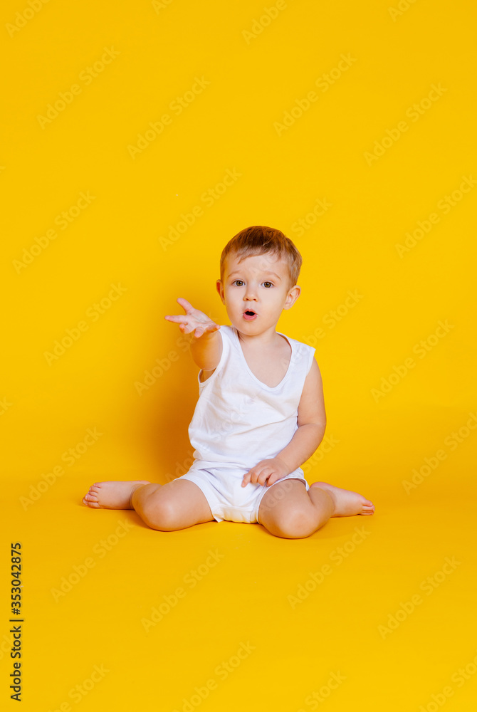 little boy in a t-shirt and underwear sitting on an orange-yellow background little boy in a t-shirt and underwear sitting on an orange-yellow background