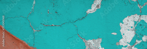 Peeling paint on the wall. Panorama of a concrete wall with old cracked flaking paint. Weathered rough painted surface with patterns of cracks and peeling. Panoramic texture for background and design. © Andrei Stepanov
