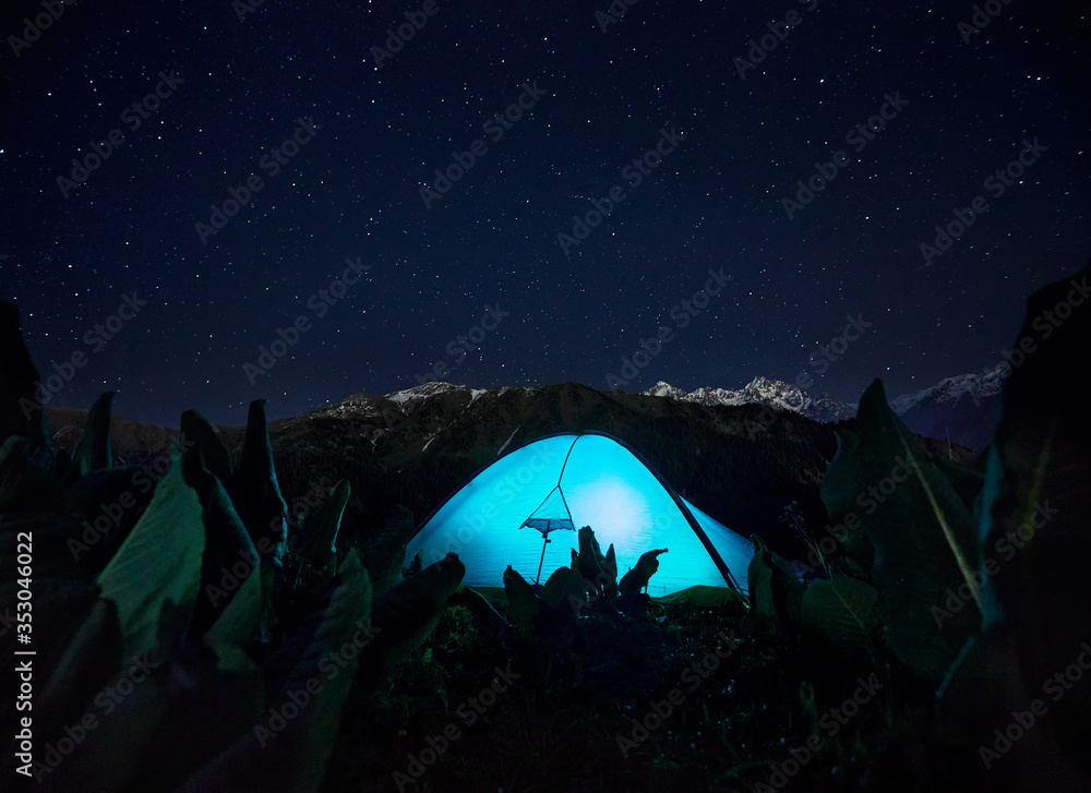 Fototapeta premium Glowing tent camping in the Night Mountains