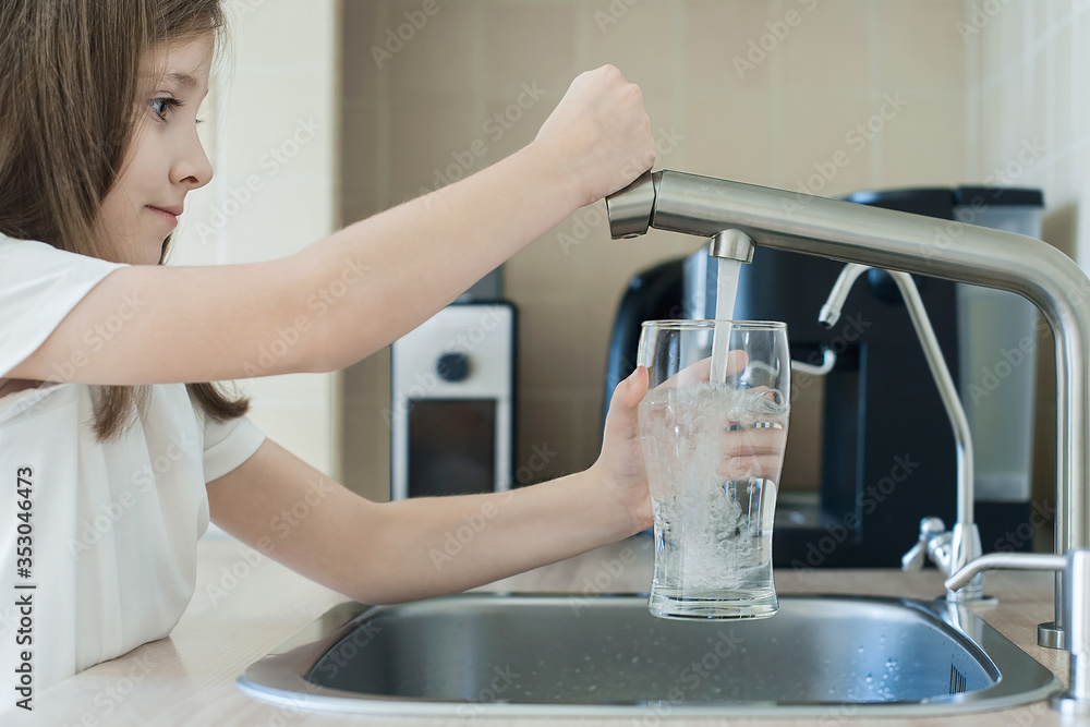 Child open water tap. Kitchen faucet. Glass of clean water. Pouring fresh drink. Hydration. Healthy lifestyle. Water quality check concept. World water monitoring day. Environmental pollution problem Child open water tap. Kitchen faucet. Glass of clean water. Pouring fresh drink. Hydration. Healthy lifestyle. Water quality check concept. World water monitoring day. Environmental pollution problem