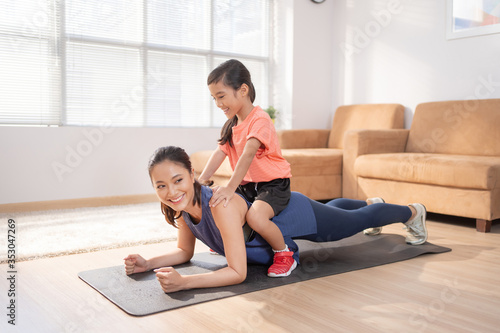 Asian mother and daughter Exercising at home they are having fun