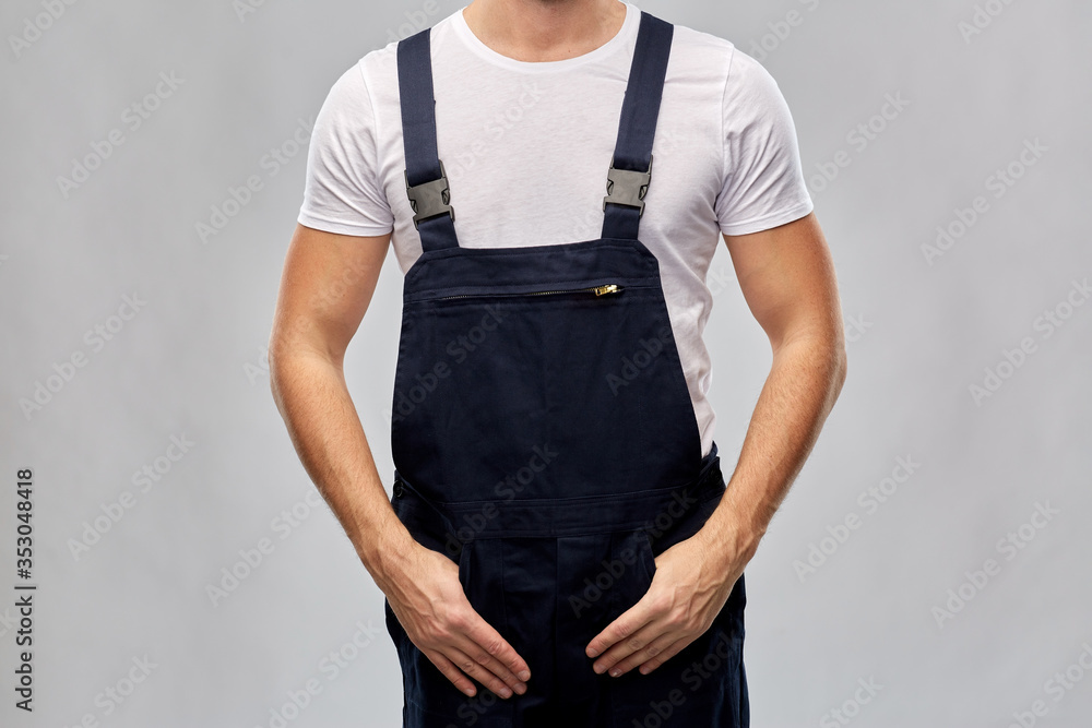 repair, construction and building - close up of male painter or builder in overall over grey background repair, construction and building - close up of male painter or builder in overall over grey background