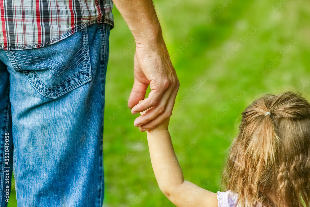 Naklejka premium beautiful hands of parent and child outdoors in the park