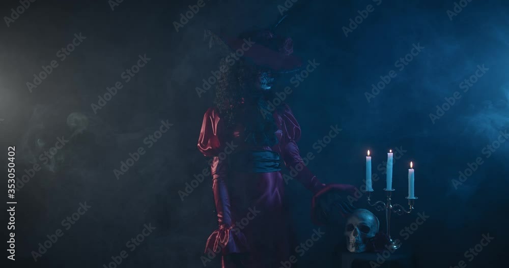 Beautiful woman with a skull paint on her face is petting a skull, Santa Muerte Beautiful woman with a skull paint on her face is petting a skull, Santa Muerte