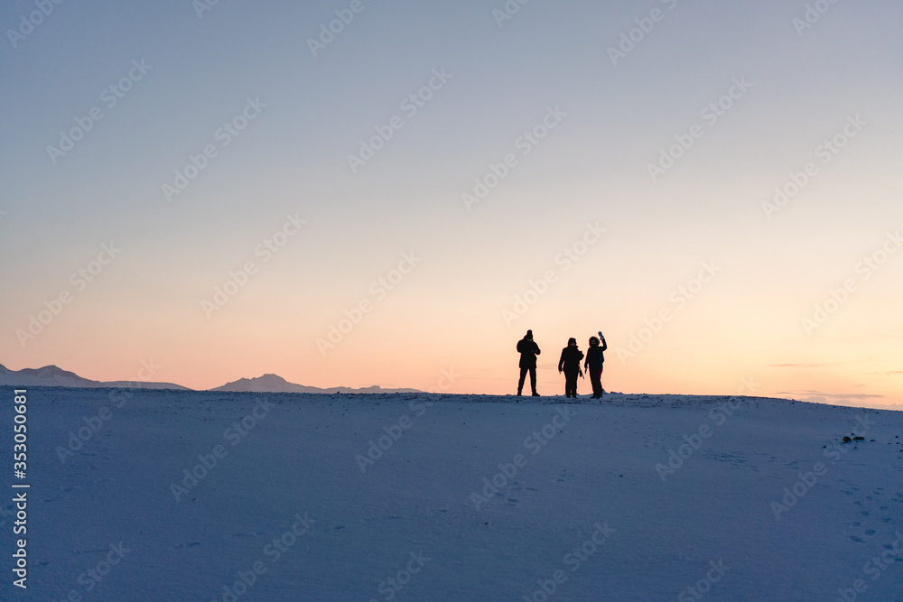 3 Personen als Silhouette in einer Schneelandschaft
