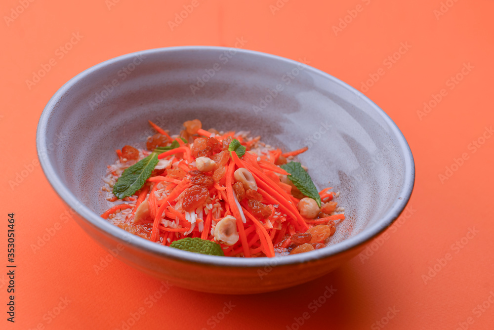 Fresh carrot salad with shredded carrots, raisins, sesame seeds and a light dressing. Served in a white bowl. Fresh carrot salad with shredded carrots, raisins, sesame seeds and a light dressing. Served in a white bowl.